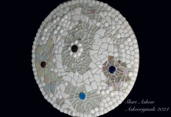 Minimalist design. What do you see. Mosaic artwork featuring intricate patterns and colorful stones on a circular base.